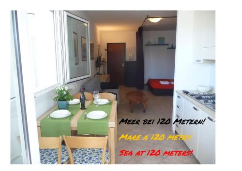 um quarto com uma mesa e cadeiras e uma cozinha em allinclusive em Lido di Jesolo
