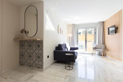 a living room with a black chair and a mirror at Hotel La Milagrosa in Alicante