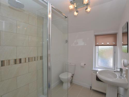 ein Bad mit einer Dusche, einem WC und einem Waschbecken in der Unterkunft 3 Bed in Lulworth 49005 in Owermoigne