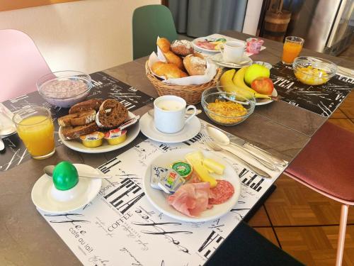 un tavolo ricoperto di piatti di prodotti per la colazione e bevande di Hotel Rondinella Locarno a Locarno