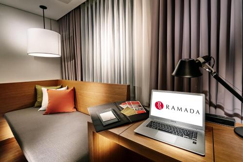 a laptop computer sitting on a desk in a hotel room at Ramada by Wyndham Gunsan in Gunsan