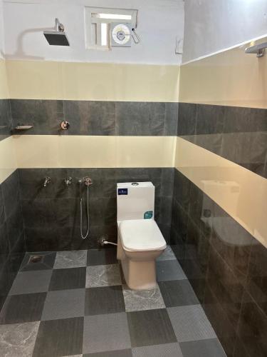 a bathroom with a toilet and a shower at The Green Thumb Farm Stay in Mundakāyam