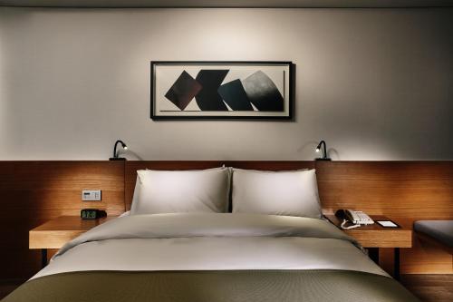 a bedroom with a bed and a picture on the wall at Ramada by Wyndham Gunsan in Gunsan