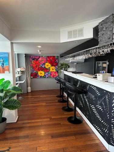 a kitchen with a bar with a painting on the wall at Highpoint International Hotel in Gladstone