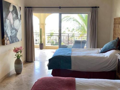 a bedroom with two beds and a large window at Entire Beachfront condo in Paradise in San José del Cabo