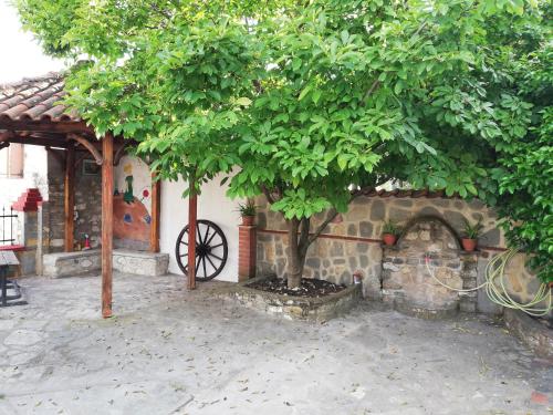 una casa con un árbol y una chimenea de ladrillo en Papa House, en Vrasná