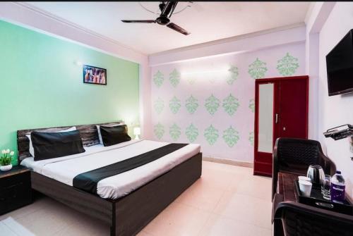 a bedroom with a bed and a television in it at SMILEY SPACE HOTEL in Noida