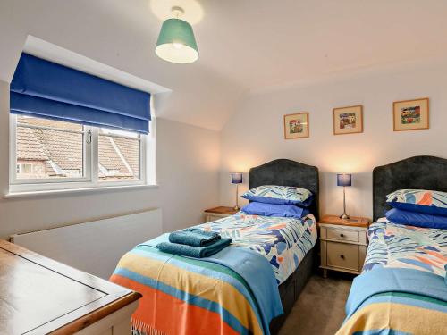 a bedroom with two beds and a table at 2 Bed in Holt 72898 in Holt