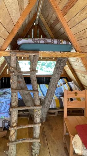 Ce lit superposé se trouve dans une chambre couverte dotée d'un lit d'appoint. dans l'établissement Cabane trappeur 4pers à la ferme aventure du perthus, à Le Perthus