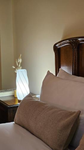 a bed with a pillow and a lamp on a table at BE Jardin Escondido By Coppola in Buenos Aires