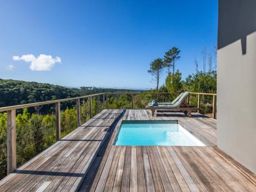 a wooden deck with a swimming pool on top of a house at Cliffside Suites in Plettenberg Bay