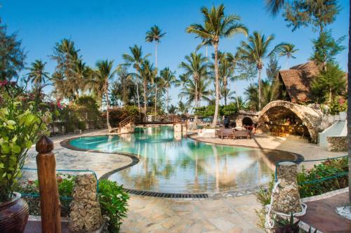 una piscina en un complejo con palmeras en Jaz Amaluna Hotel, en Uroa