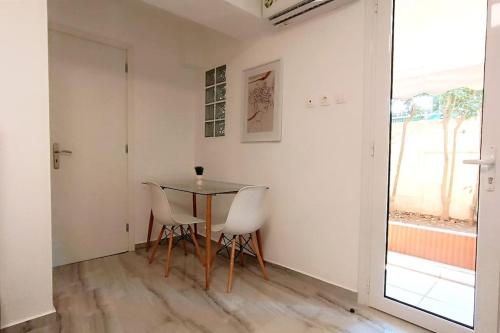 - une salle à manger avec une table et deux chaises dans l'établissement Cozy modern apartment White Serenity, à Athènes