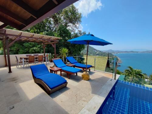 une terrasse avec des chaises et un parasol ainsi qu'une piscine dans l'établissement Sandalwood Luxury Villa Resort, à Lamai