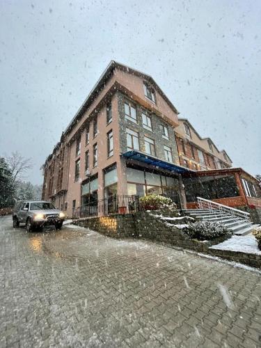 a large brick building on a street in the snow at Kazdağ Göknar Otel in Yenice