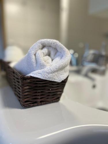 un cesto di asciugamani poggiato su un lavandino del bagno di Lilly's Häuschen a Obereisenheim