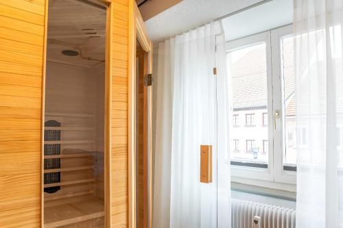 einen Schrank mit einem Spiegel und einem Fenster in der Unterkunft Black Forest Moments inkl. Sauna für 8 Personen in Hüfingen
