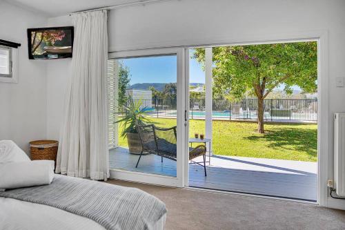 una camera da letto con porta scorrevole in vetro che si apre su un patio di 'Bonnie View' A Magnificently Luxurious Retreat a Mudgee