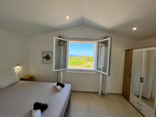 - une chambre avec un lit et une fenêtre dans l'établissement Ancienne bergerie de Monteleone vue mer et Citadelle, à Bonifacio