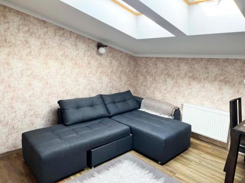 a living room with a blue couch and a skylight at Апарт-отель "ГАЛАГОВЪ" in Uzhhorod
