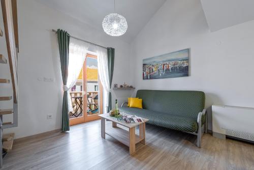 a living room with a green couch and a table at Cina Apartments in Cavtat