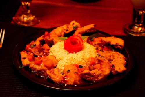 a plate of food with shrimp and rice on a table at Peacock Beach Hotel Unawatuna in Unawatuna