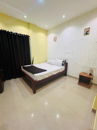 a bedroom with a bed and a table in it at Leisure familyvillas in Padinjarathara