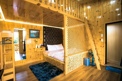 1 dormitorio con 1 cama en una habitación de madera en Dớt's Garden Homestay, en Da Lat