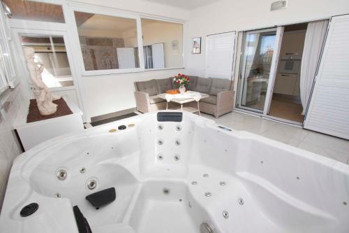 eine große weiße Badewanne im Wohnzimmer in der Unterkunft Apartment Stipe Makarska in Makarska