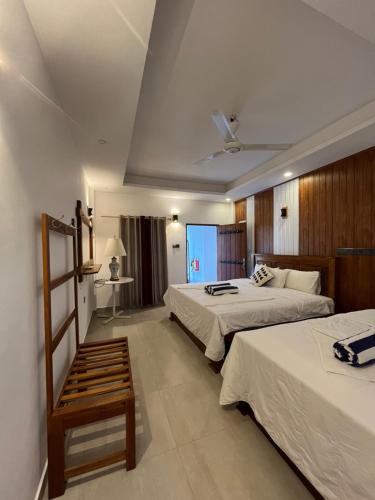 a hotel room with two beds and a window at NN Beach Resort & SPA in Nilaveli
