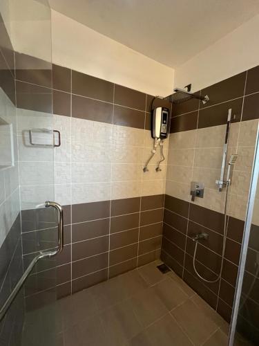 a bathroom with a shower with a phone on the wall at NN Beach Resort & SPA in Nilaveli