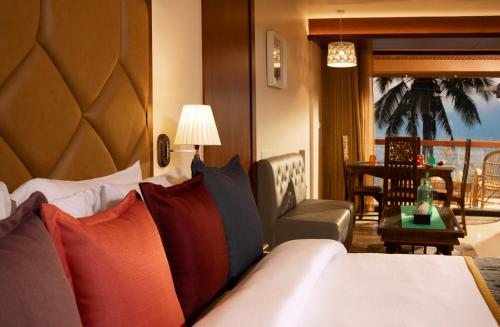 a hotel room with a bed and a chair and a table at Uday Samudra Leisure Beach Hotel & Spa in Kovalam