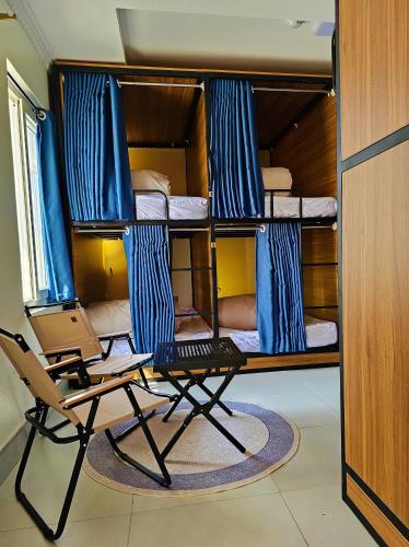 a room with bunk beds with a laptop and a chair at Frontier Hostel & Tours in Dien Bien Phu