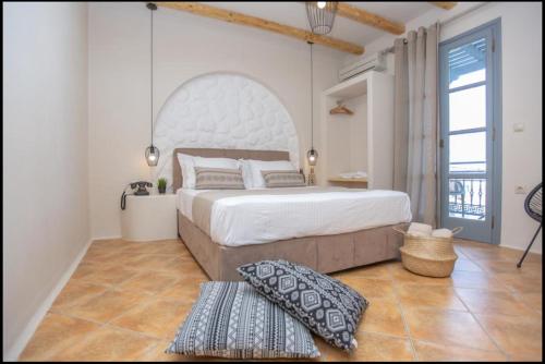 a bedroom with a large bed and a large window at Ampelos Prokopios in Agios Prokopios