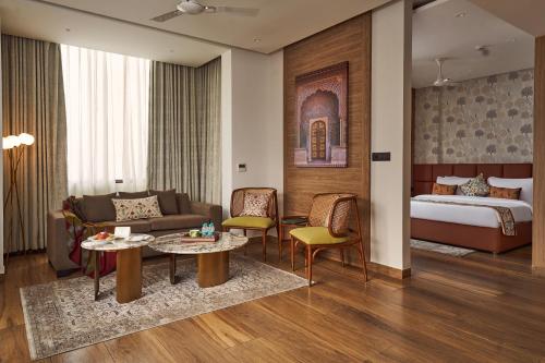 Habitación de hotel con cama y sala de estar. en Triptam Vrindavan en Vrindāvan