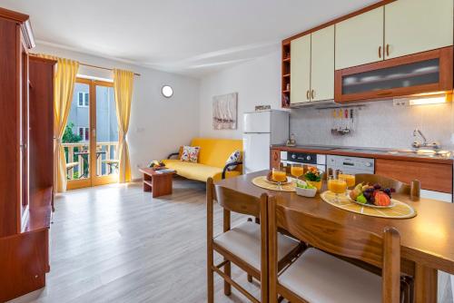 cocina y sala de estar con una mesa con fruta. en Cina Apartments, en Cavtat