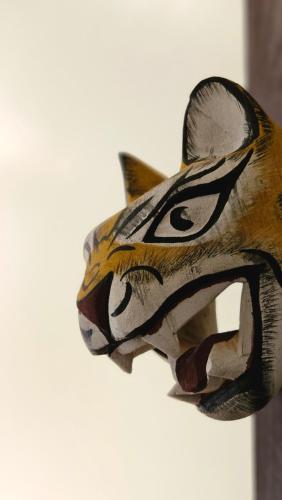 a wooden cat mask hanging on a wall at BE Jardin Escondido By Coppola in Buenos Aires