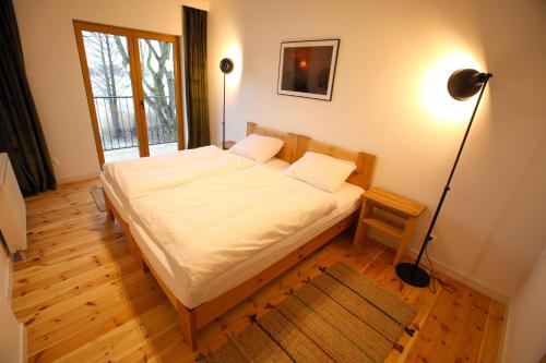 a bedroom with a bed and a floor lamp at Kaktus in Pasym