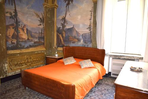 - une chambre dotée d'un lit avec des draps orange et un tableau dans l'établissement La Perla Antica, à Vietri