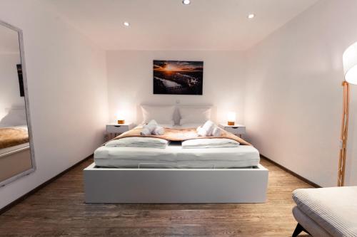 Moderne Stadtwohnung an der Fussgängerzone, Smart TV, Kingsize-Bett, Couch, Küche في باساو: غرفة نوم مع سرير أبيض كبير في غرفة