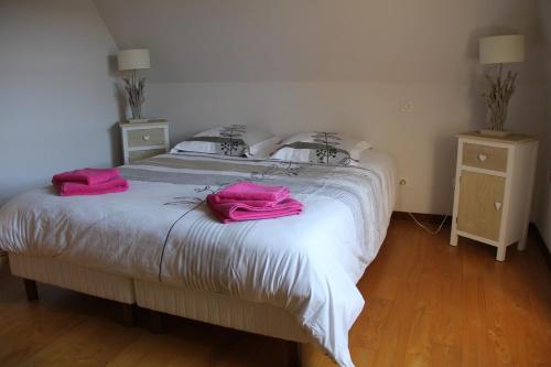 a bedroom with a bed with pink towels on it at Le Coeur de Domme in Domme