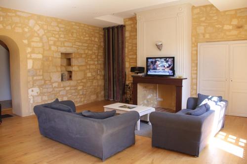 a living room with two couches and a fireplace at Le Coeur de Domme in Domme