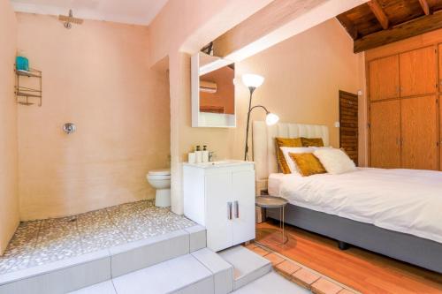 Schlafzimmer mit einem Bett, einem WC und einem Waschbecken in der Unterkunft Airbnb at Bailyes in Pretoria