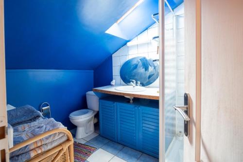 a blue bathroom with a sink and a toilet at La Ferme de Leychoisier in Bonnac-la-Côte