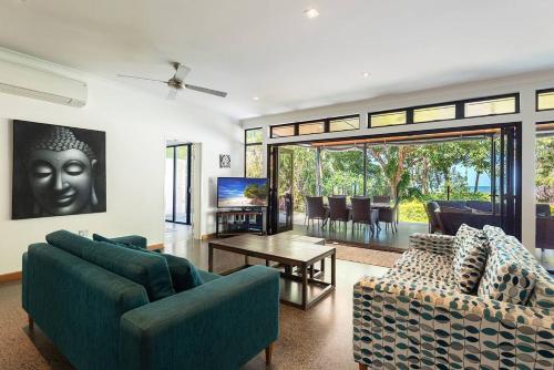a living room with two couches and a table at Bramston Beach - Premium Holiday House in Bramston Beach