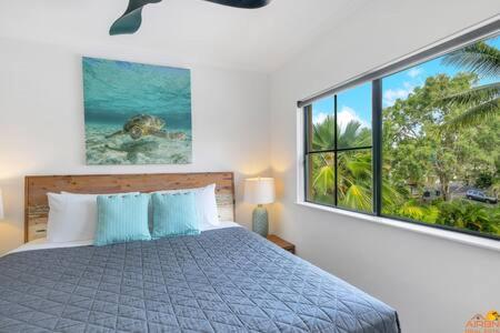 een slaapkamer met een bed en een groot raam bij Port Douglas Vacation Holiday Unit in Port Douglas