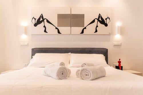 a bedroom with a white bed with towels on it at CeO LUXURY SUITE DI CAGLIARI in Cagliari
