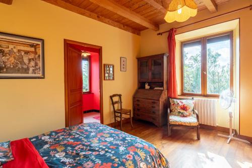 1 dormitorio con 1 cama, vestidor y ventana en La Ferme de Leychoisier, en Bonnac-la-Côte