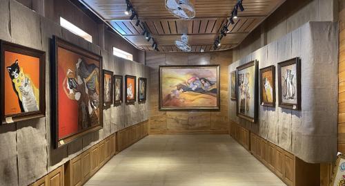 a hallway with paintings on the walls of a museum at Lotus Garden Muine Resort & Spa in Mui Ne
