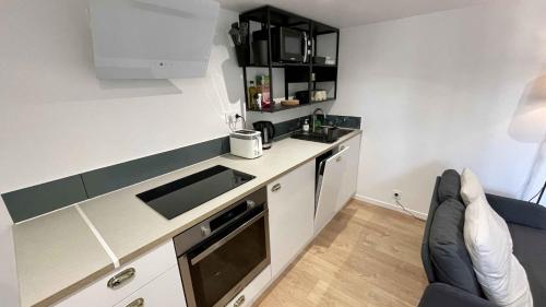 Una pequeña cocina con fregadero y encimera. en Appartement au calme dans le quartier historique pour 4 personnes avec espace extérieur, en Pau